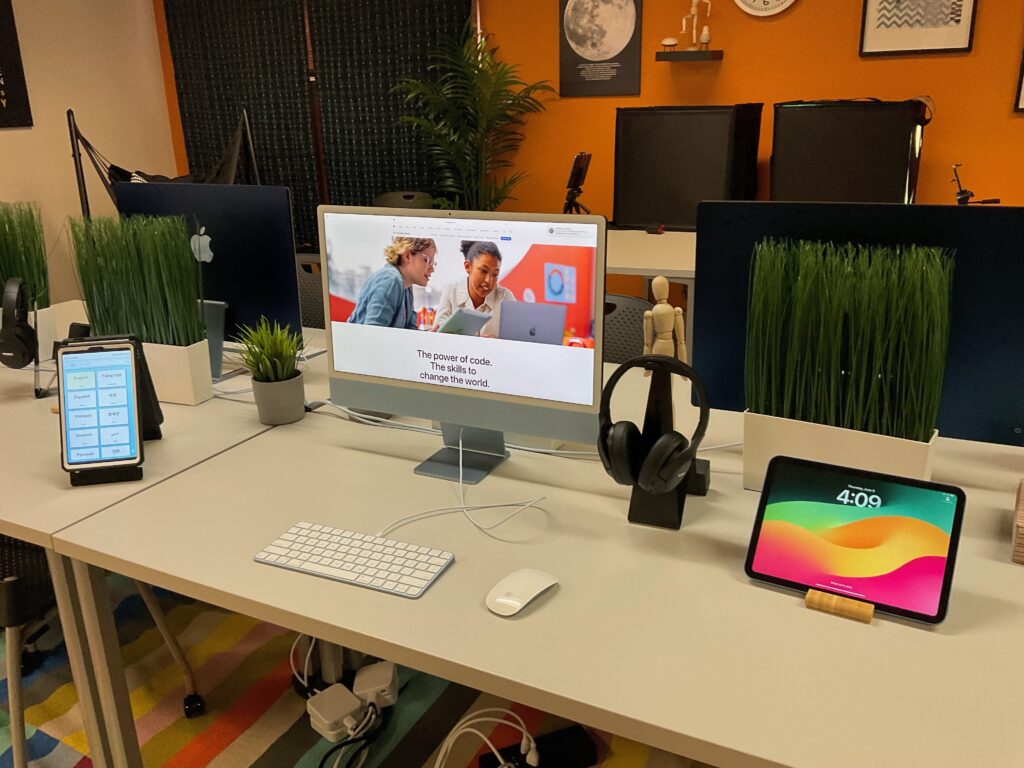 A desk at The Hive with a desktop computer and other technology set up and ready to use, in a friendly and inviting space